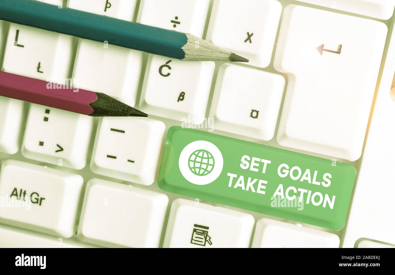 Writing note showing Set Goals Take Action. Business concept for Act on a specific and clearly laid out plans White pc keyboard with note paper above Stock Photo