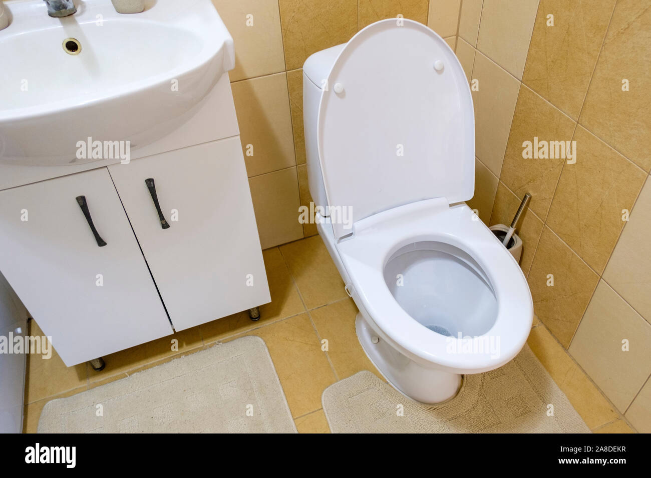 Toilet and hand basin in a compact bathroom with shower Stock Photo