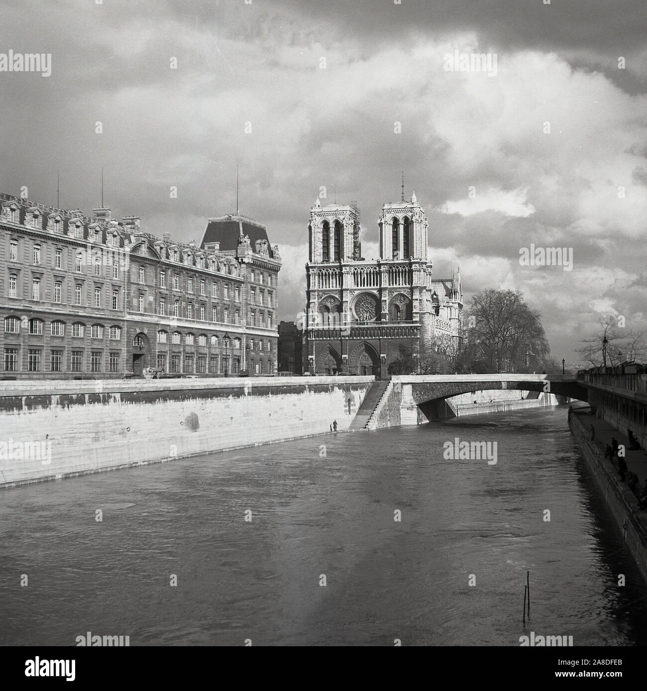 1950s, historical, View from Pont au Double across the river Seine to The Notre-Dame Cathedral, Paris, France. A medieval Catholic church on the IIe de la Cite in the 4th arrondissement of Paris, it is considered one of the finest examples of French Gothic architecture. Stock Photo