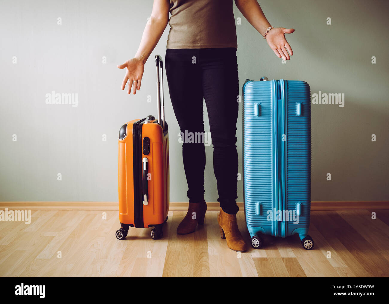 Confused air passenger standing with luggage, stranded in airport. Traveling agency bankruptcy concept. Stock Photo