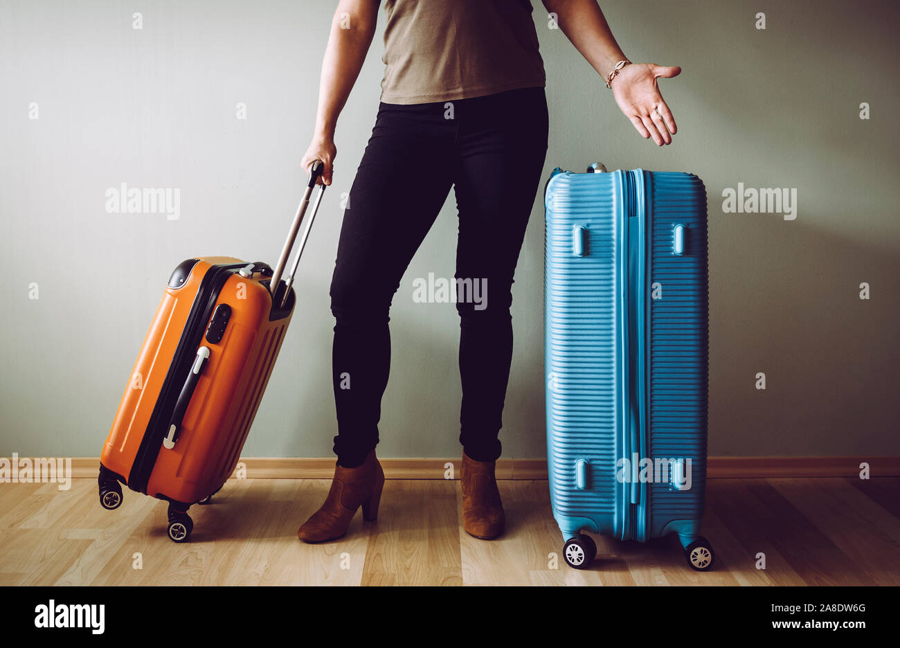 Confused air passenger standing with luggage, stranded in airport. Traveling agency bankruptcy concept. Stock Photo