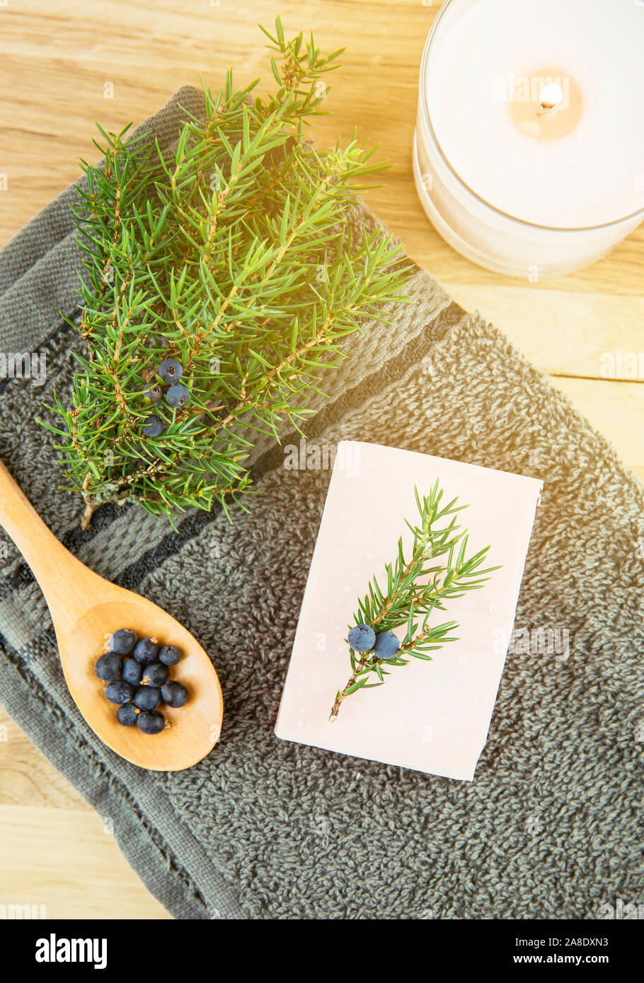 Flat lay view Juniper latin Juniperus communis berry soap bar, juniper tree branch with confier cones and spoon with berries, copy space.  Juniper tre Stock Photo
