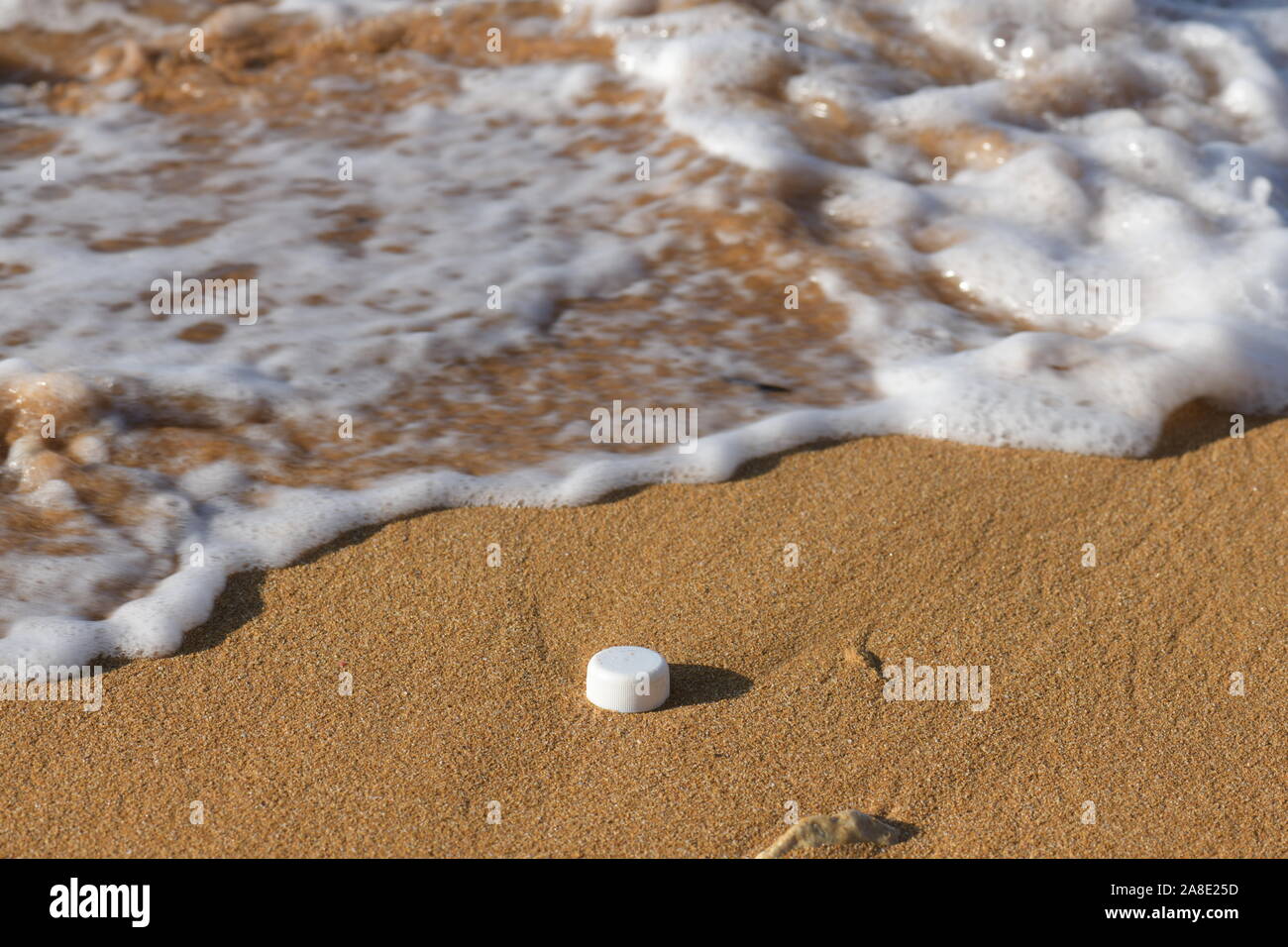 Plastic polution on sand beach with sea in view Stock Photo
