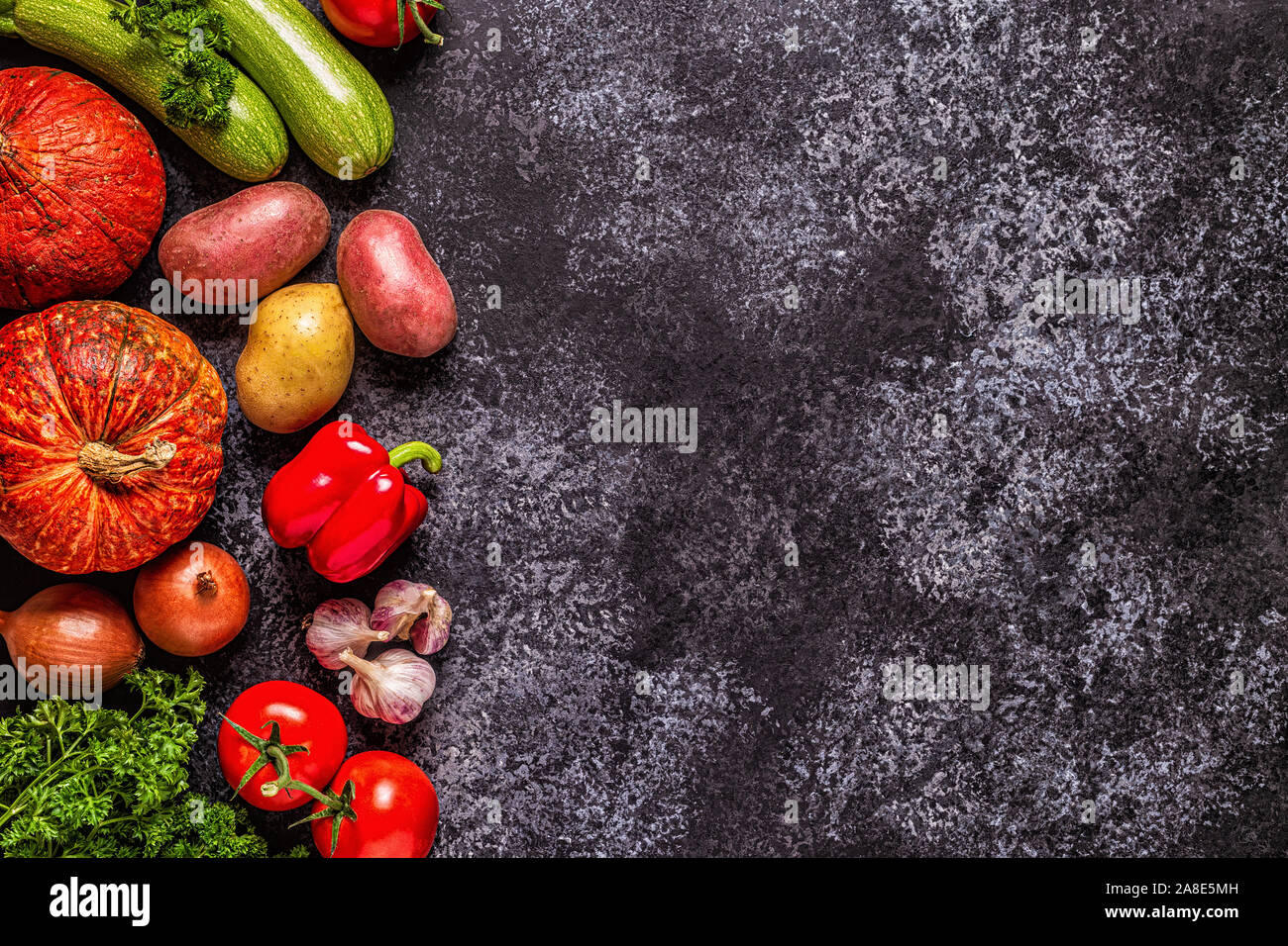 Fresh autumn vegetables for cooking on a dark background, top view. Stock Photo