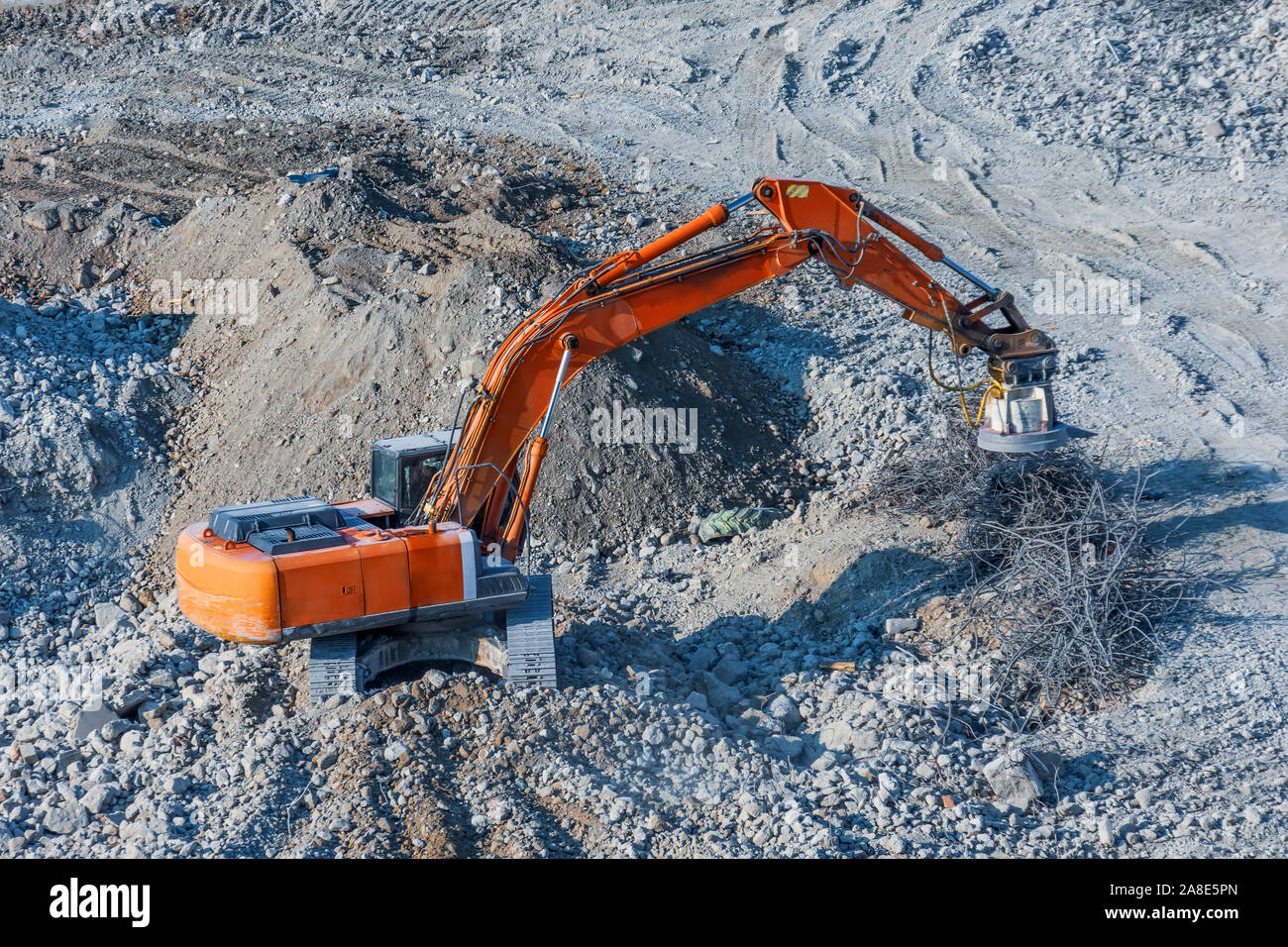 Excavator with a magnet on the boom for loading metal waste cargo Stock Photo