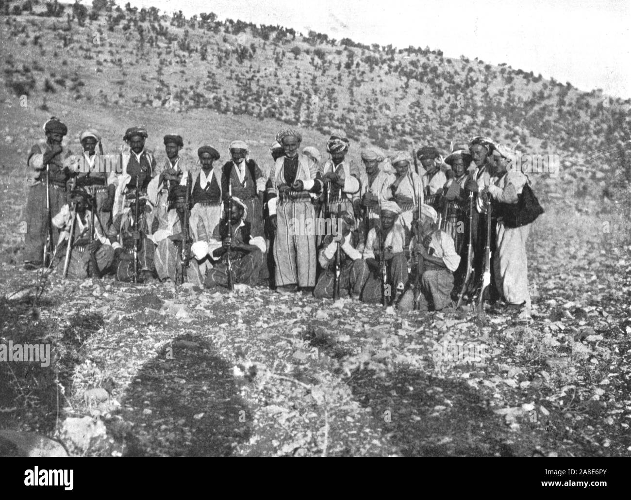 'Ahmed Agha', c1906-1913, (1915). Kurdish men with rifles and bullet belts, Shirwan, (eastern Turkey). 'A little further on we met Ahmed Agha and fifty gunmen. The Agha was a tall, handsome old man, with a pathetic and harassed expression. He pointed sadly to the smoking ruins beyond the river, and showed us the wretched burnt-out inhabitants, collecting wood and stones with which to build fresh houses...When I saw this devastation, I began to think of the advantages of centralised government over feudal times'. From &quot;The Caliphs' Last Heritage, a short history of the Turkish Empire&quot; Stock Photo