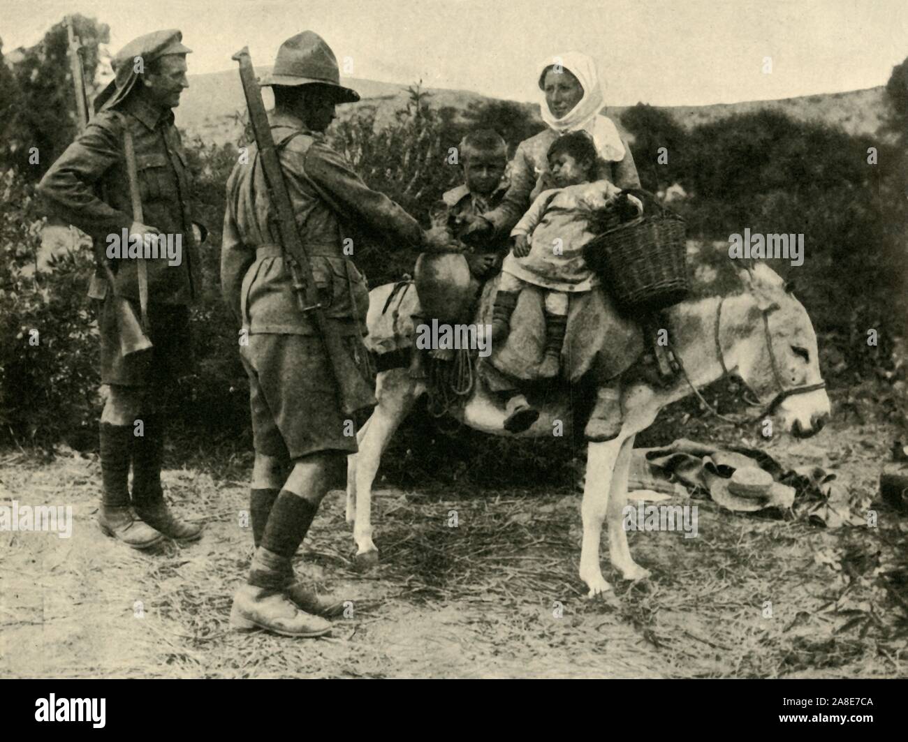 Australian soldier giving water to a Turkish family, First World War, 1915-1916, (c1920). 'A Dardanelle Idyll: Australian giving a drink of water to a Turkish peasant woman above Anzac Cove', on the Gallipoli peninsula in Turkey. From &quot;The Great World War: A History&quot;, Volume V, edited by Frank A Mumby. [The Gresham Publishing Company Ltd, London, c1920] Stock Photo
