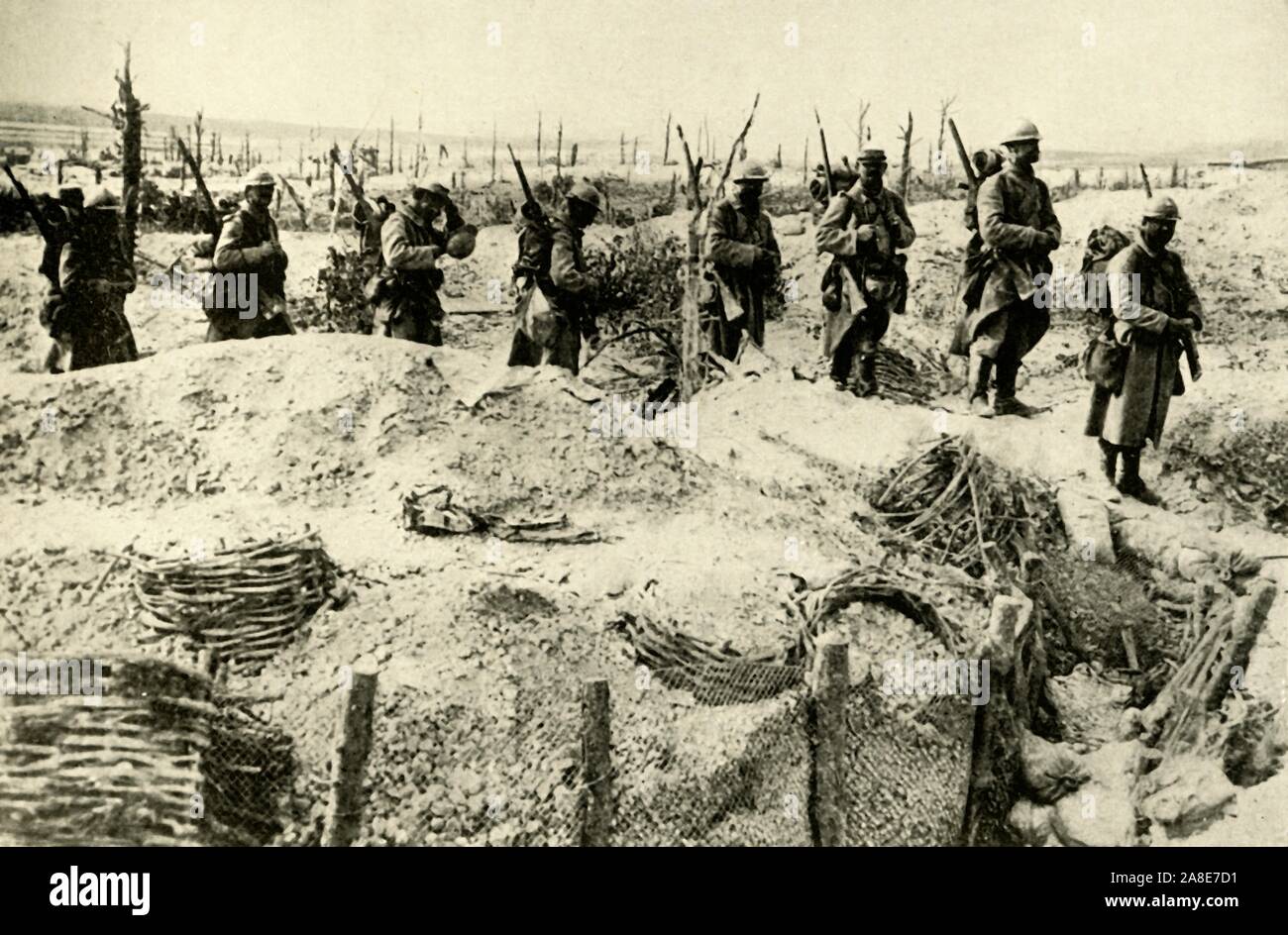 French soldiers occupy captured German trenches, Champagne, northern France, First World War, 1915-1916, (c1920). 'The Armoured Man and the Armoured Trench: French soldiers, wearing their new steel helmets, entering one of the shattered German Trenches in the Sabot Wood, Champagne'. From &quot;The Great World War: A History&quot;, Volume V, edited by Frank A Mumby. [The Gresham Publishing Company Ltd, London, c1920] Stock Photo