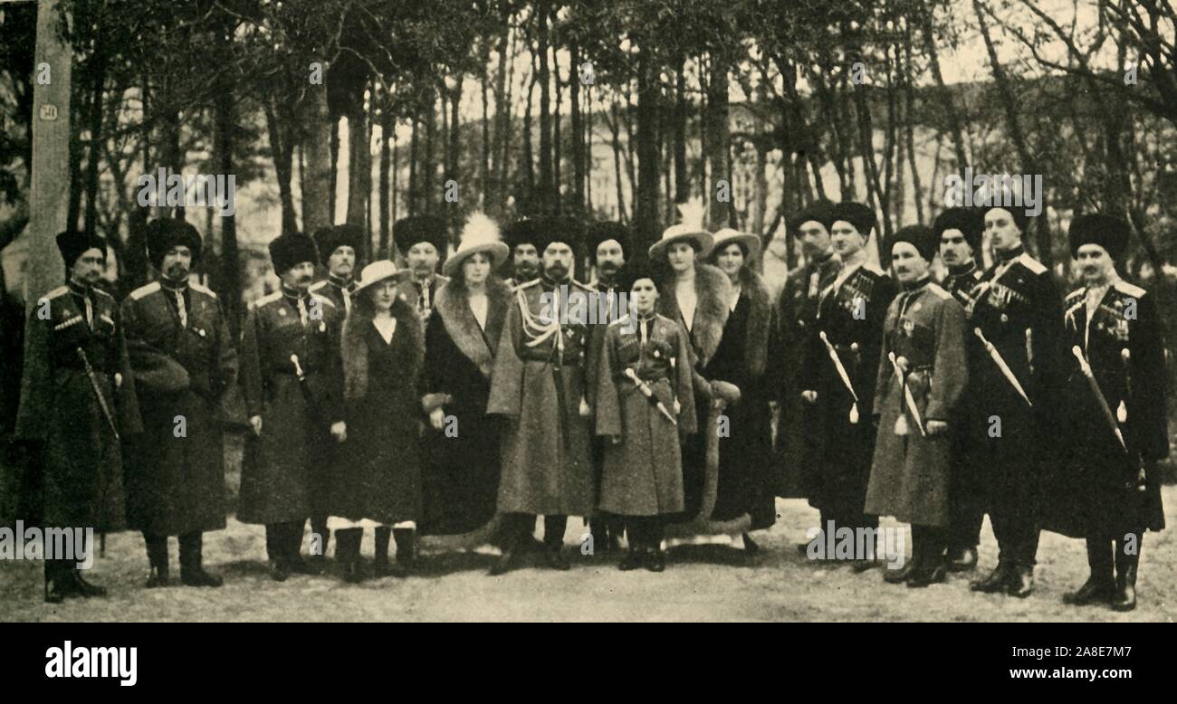 The Russian royal family, c1917, (c1920). 'An Imperial Group in Russia shortly before the Revolution: the ex-Tsar Nicholas with his son and daughter and a party of Russian officers...The figures in the central group...left to right, are those of the Grand-Duchess Anastasia, the ex-Tsar's youngest daughter: General Count Grabb&#xe9; (standing behind): the Grand-Duchess Olga, the ex-Tsar's eldest daughter; Nicholas II; the Grand-Duke Alexis (ex-Tsarevitch) : and the Grand-Duchesses Tatiana and Marie'. The Tsar and Tsarina, their five children, their doctor and three of their servants were execut Stock Photo