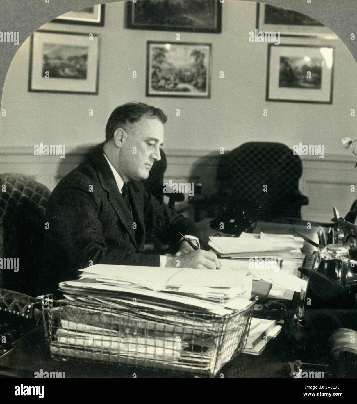 'Franklin Delano Roosevelt, President of the United States at His Desk in the Executive Offices, Washington D.C', c1930s. President Roosevelt, 32nd president of the United States from 1933 until his death in 1945. From &quot;Tour of the World&quot;. [Keystone View Company, Meadville, Pa., New York, Chicago, London] Stock Photo