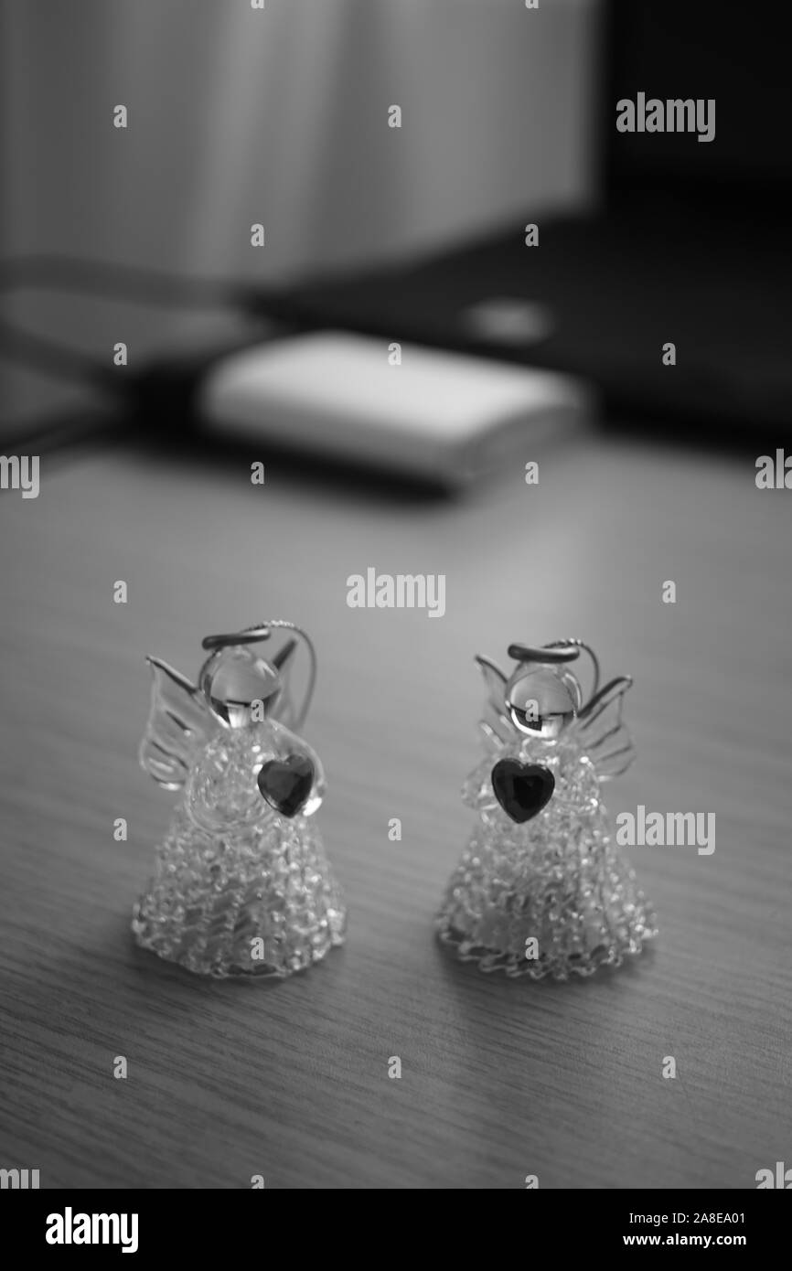 Small figures of angels with hearts. Holiday toys. Bw photo. Stock Photo