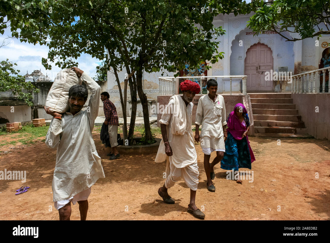 Pushkar, Rajasthan, India: a group of Indian men and women cross a courtyard Stock Photo