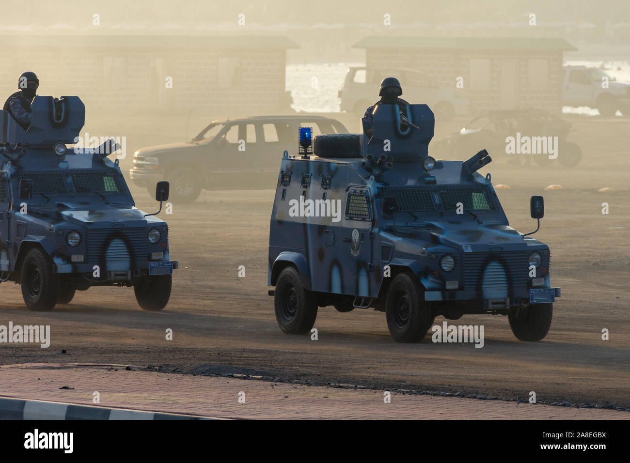 Military police vehicles enforcing law and order in protest, war, and conflict driving across the desert, Stock Photo