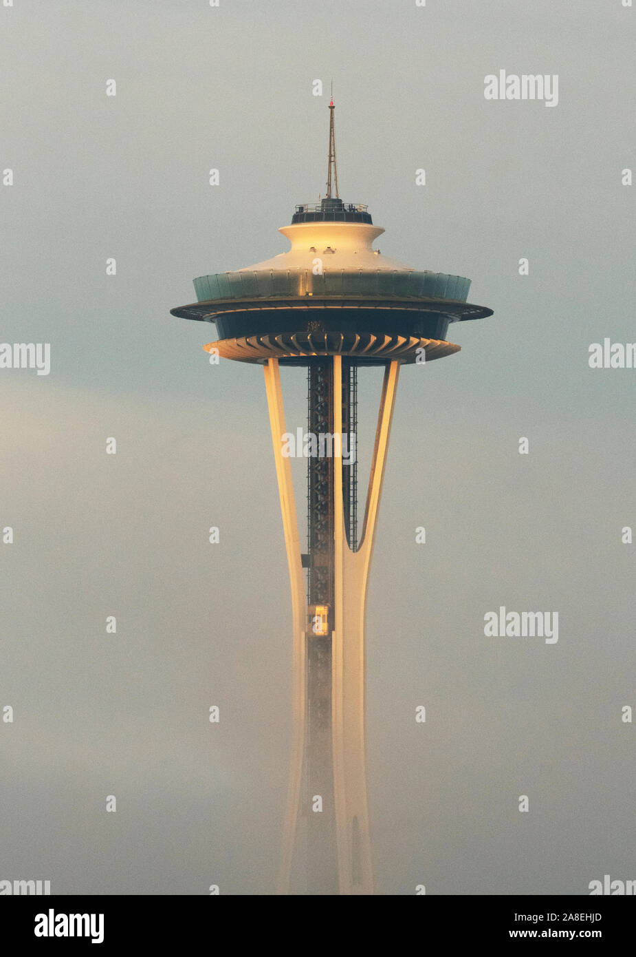 Space Needle on foggy winter morning, Seattle, Washington : Golden elevator descends into mist Stock Photo