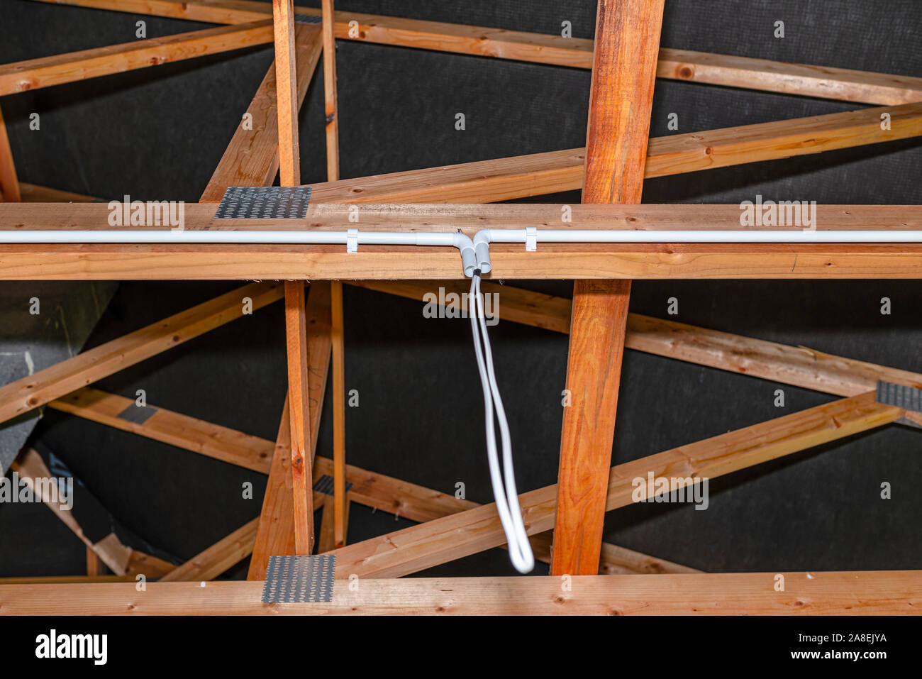 Lighting cables in plastic wiring pipes in a newly built house mounted on roof trusses Stock