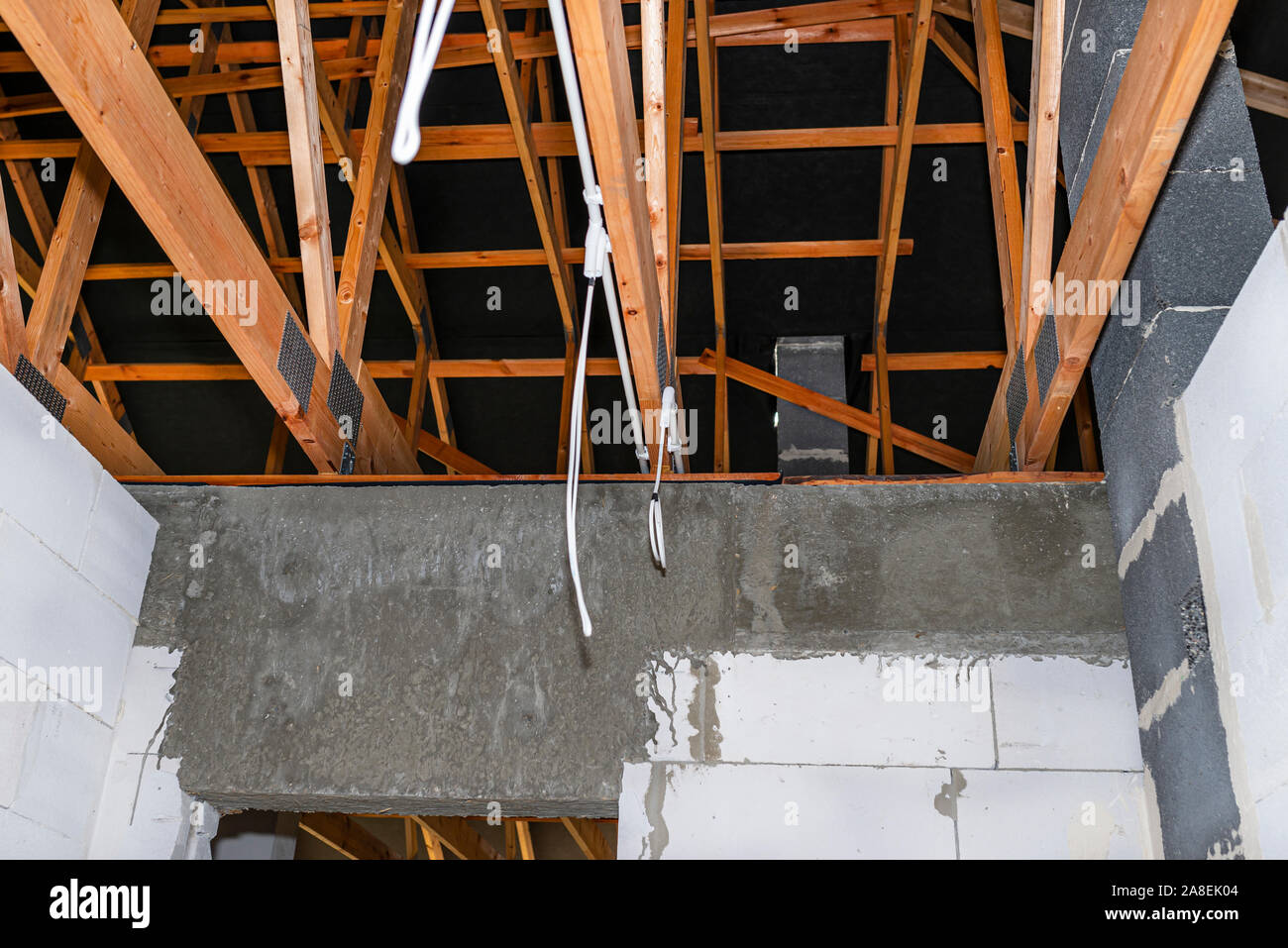 Lighting cables in plastic wiring pipes in a newly built house mounted on roof trusses Stock