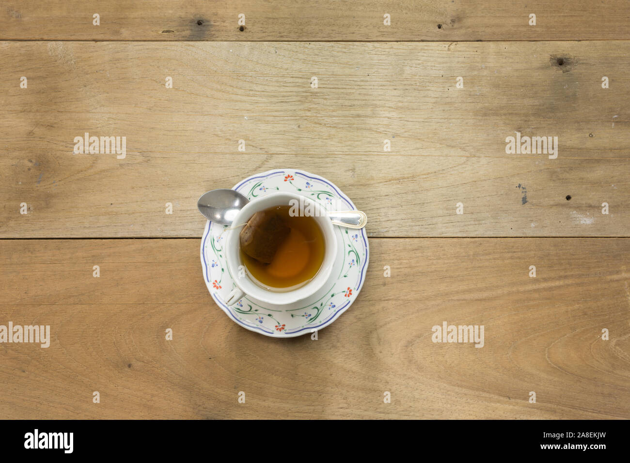Assam tea bag, cup on the saucer, a spoon is placed on the saucer, on
