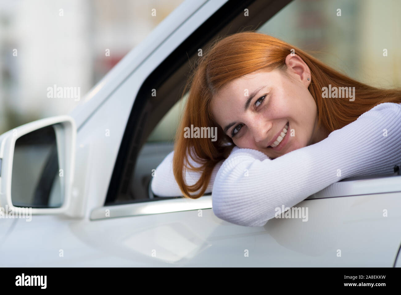Young woman with red hair driving a car Stock Photo - Alamy
