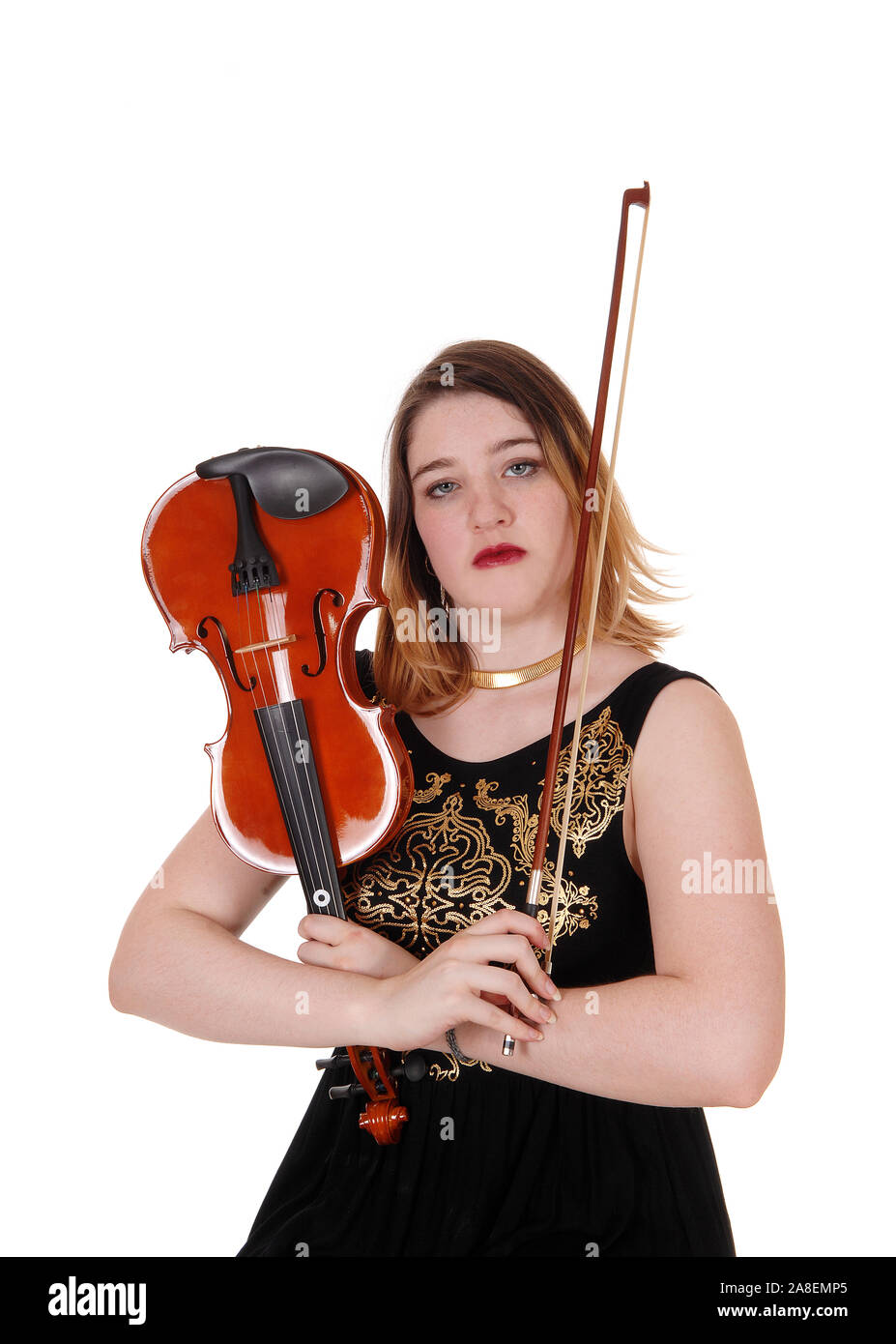 A close up image of a woman sitting on a chair holding up her violin ...