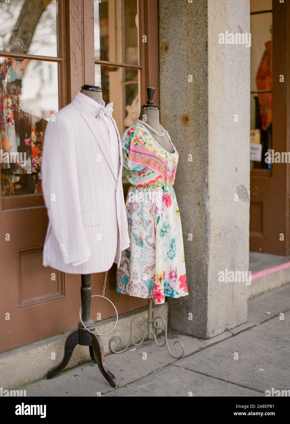 A seersucker sport coat with bowtie and a woman's dress on a  mannequin in front of a shop in the French Quarter, New Orleans, Louisiana Stock Photo