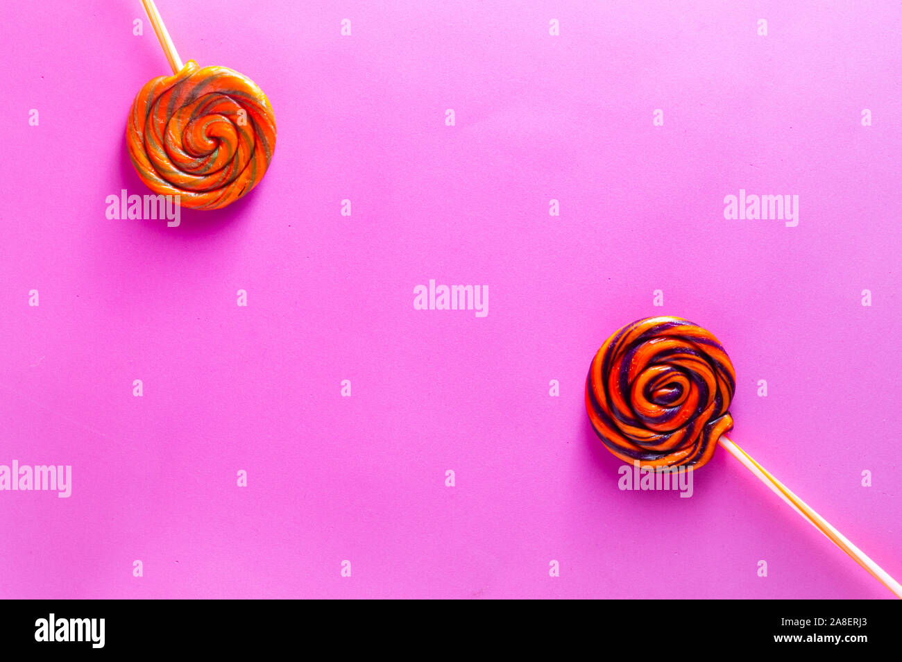 Colorful candy lollipops isolated on pink background. Orange, purple ...