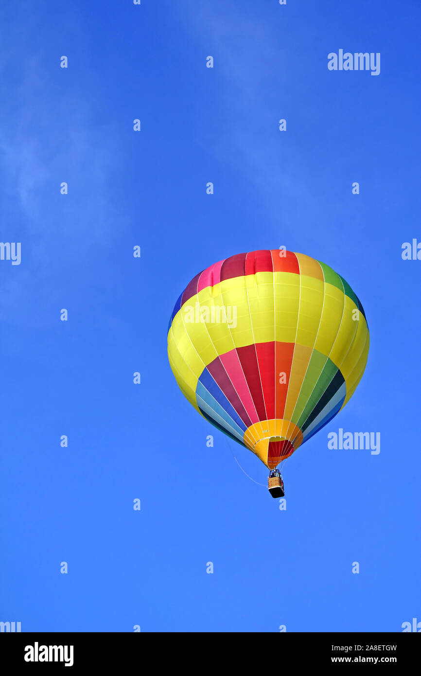 Bunter Heissluftballon schwebt vor blauen Himmel. Stock Photo