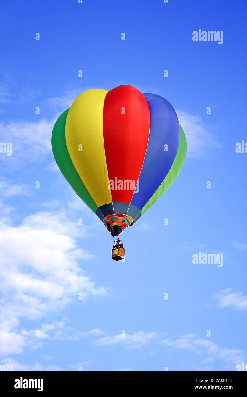Bunter Heissluftballon schwebt vor blauen Himmel. Stock Photo
