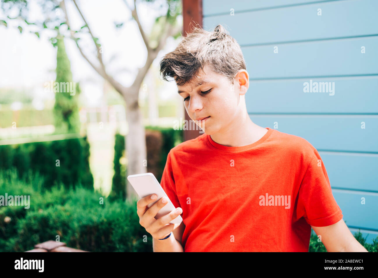 Profile of a happy guy texting on a smart phone Stock Photo