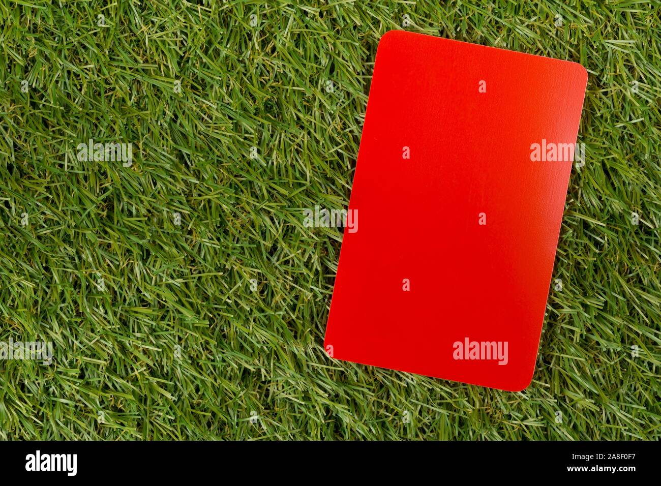 Soccer sports referee red card on grass background penalty, foul or