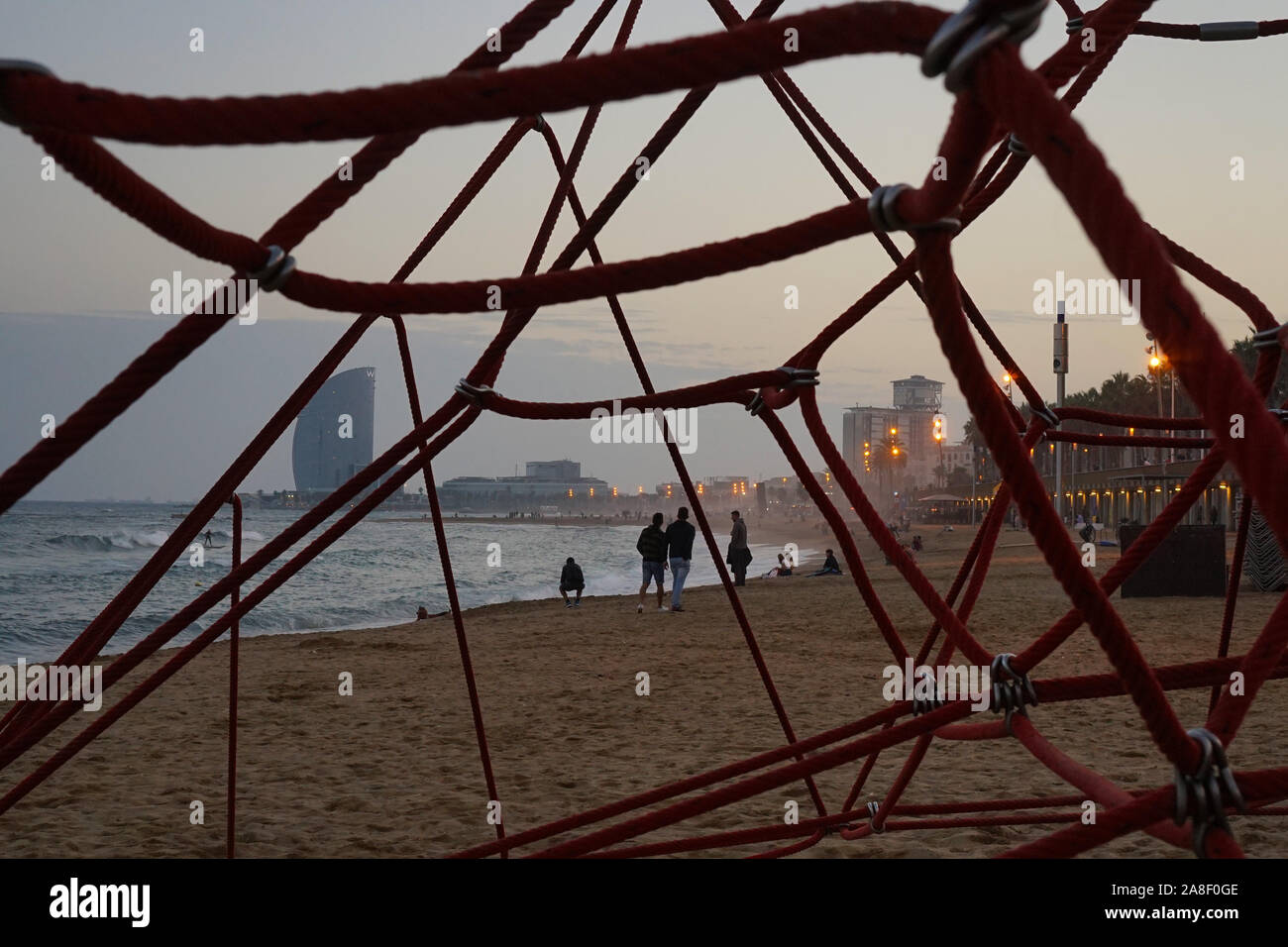 A view of Barcelona city beach through the geometric shapes of a rope climber Stock Photo
