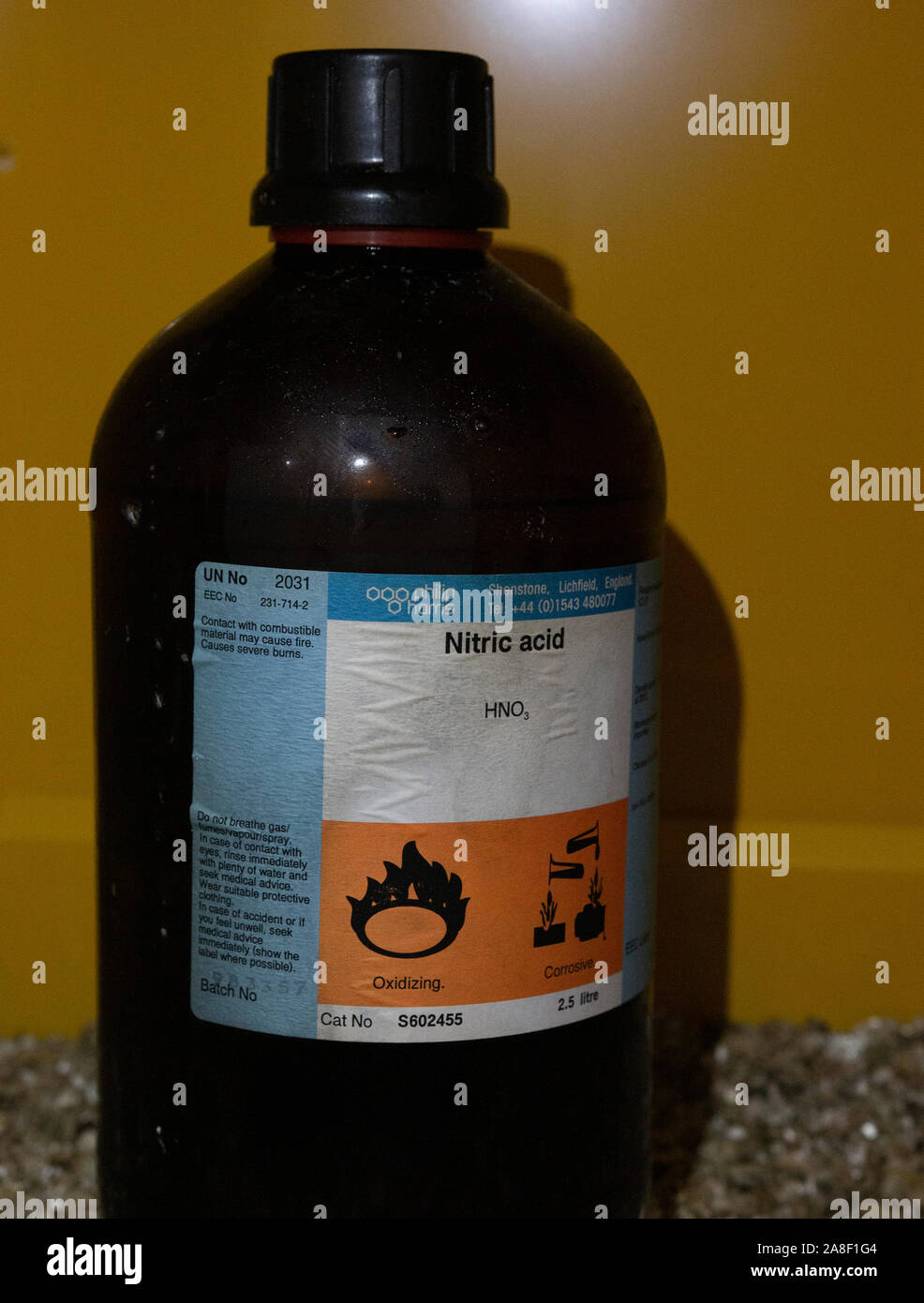Old glass stock bottle of nitric acid in a chemical store in the UK Stock Photo