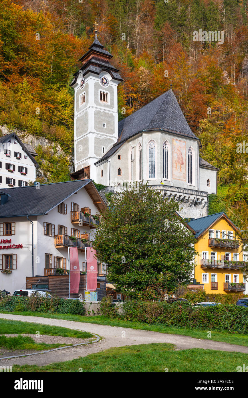 The Catholic parish church with fall foliage color in Hallstatt, Austria, Europe. Stock Photo