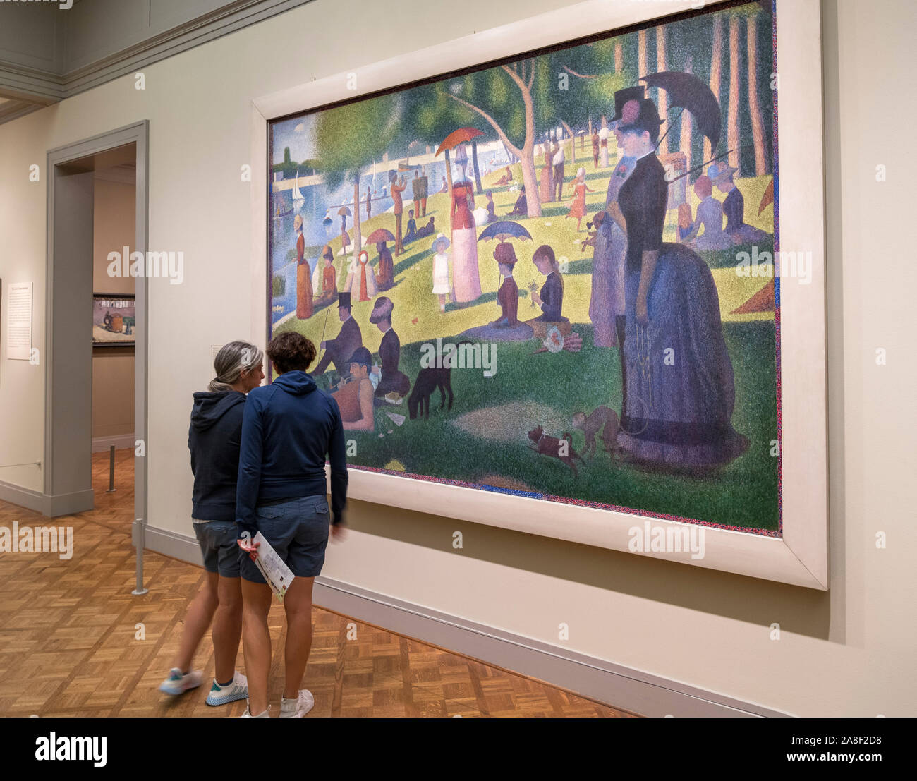 Two visitors looking at the painting 'A Sunday on La Grande Jatte' by Georges Seurat, Art Institute of Chicago, Chicago, Illinois, USA Stock Photo