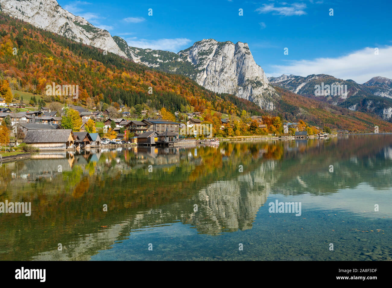Fall foliage color in the trees and the calm lake with reflections at