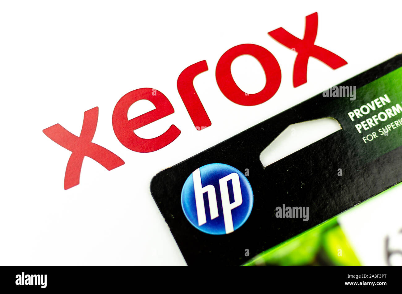 XEROX and HP logos seen on paper and printer cartridge ink. Concept photo - XEROX is a paper, HP is an ink. Selective focus. Stock Photo