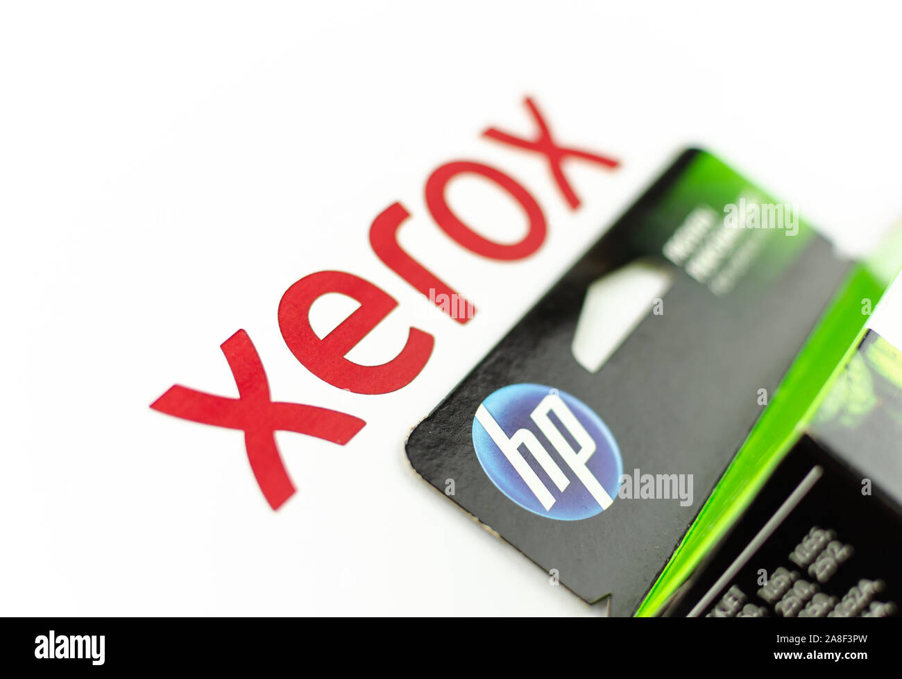 XEROX and HP logos seen on paper and printer cartridge ink. Concept photo - XEROX is a paper, HP is an ink. Selective focus. Stock Photo