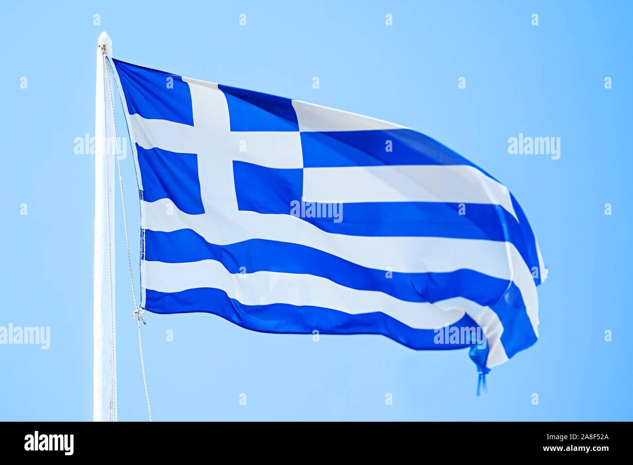 Eine griechische Flagge unter blauem Himmel, Griechische Fahne, Flaggenmast, Fahnenmast, blauer Himmel, Stock Photo
