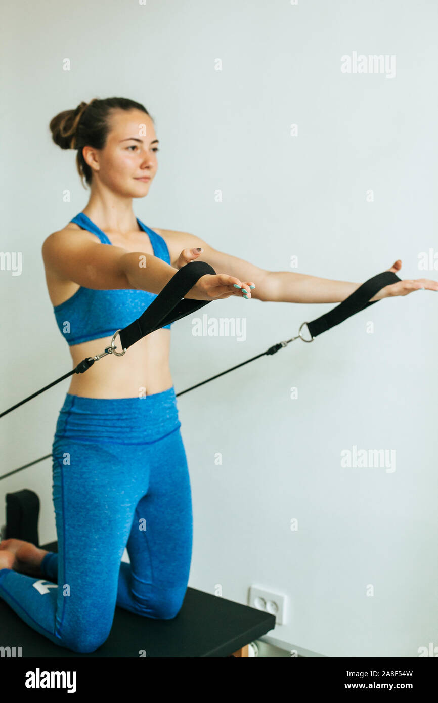 Woman performing Pilates exercise using a Cadillac or Trapeze table Stock Photo