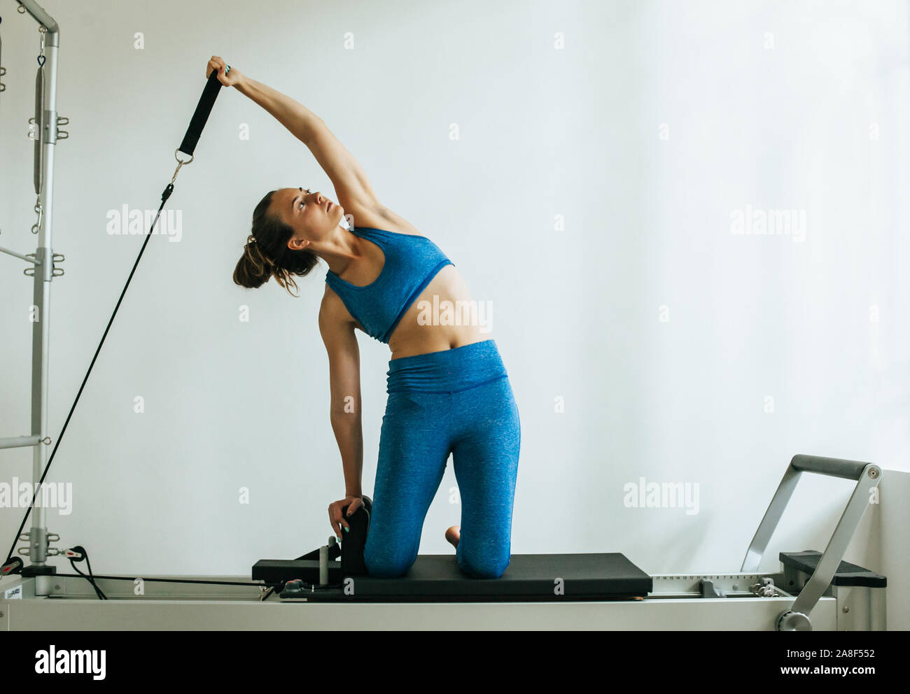 Woman performing Pilates exercise using a Cadillac or Trapeze table Stock Photo