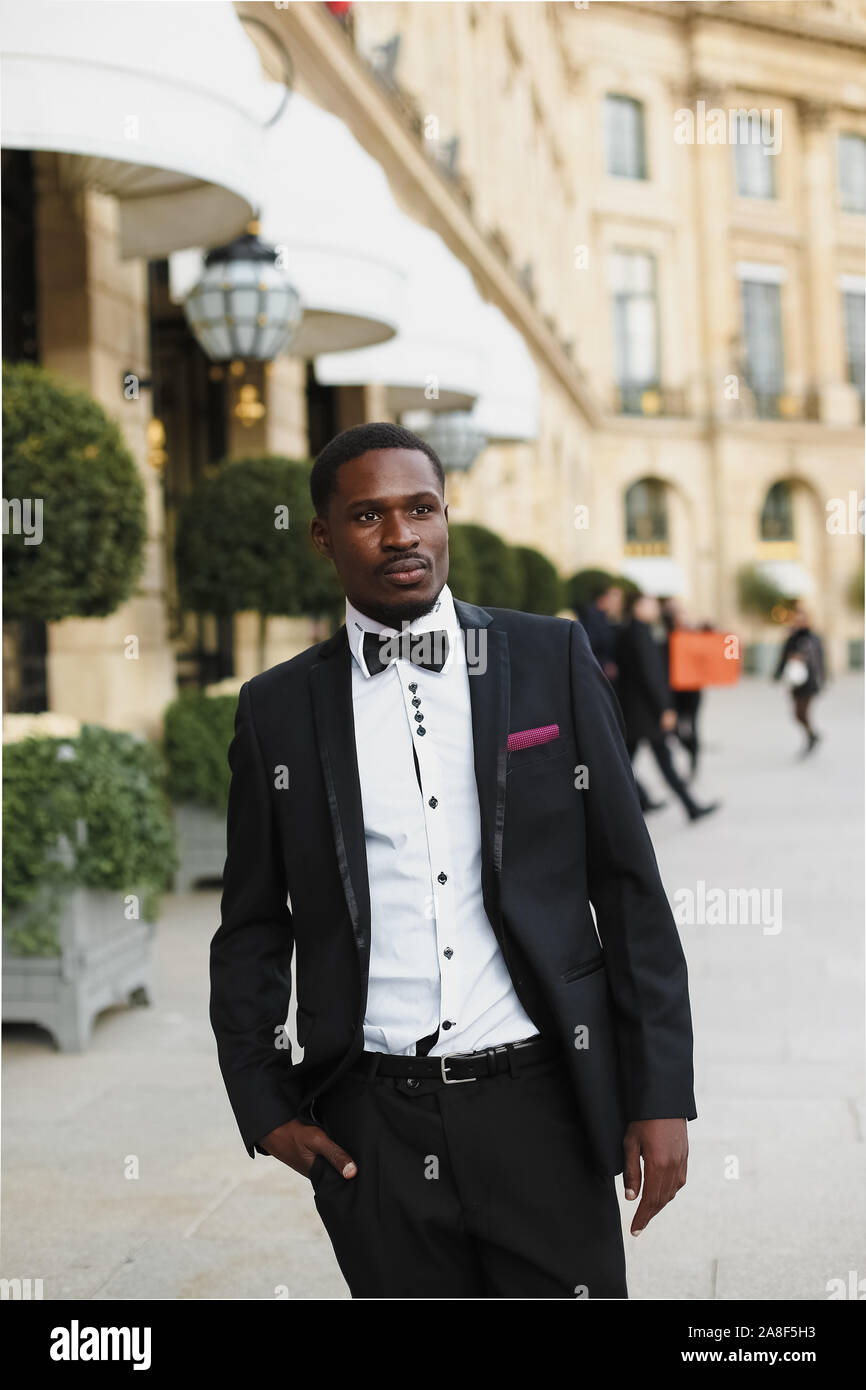 Afro american man wearing suit and standing near building Stock Photo ...