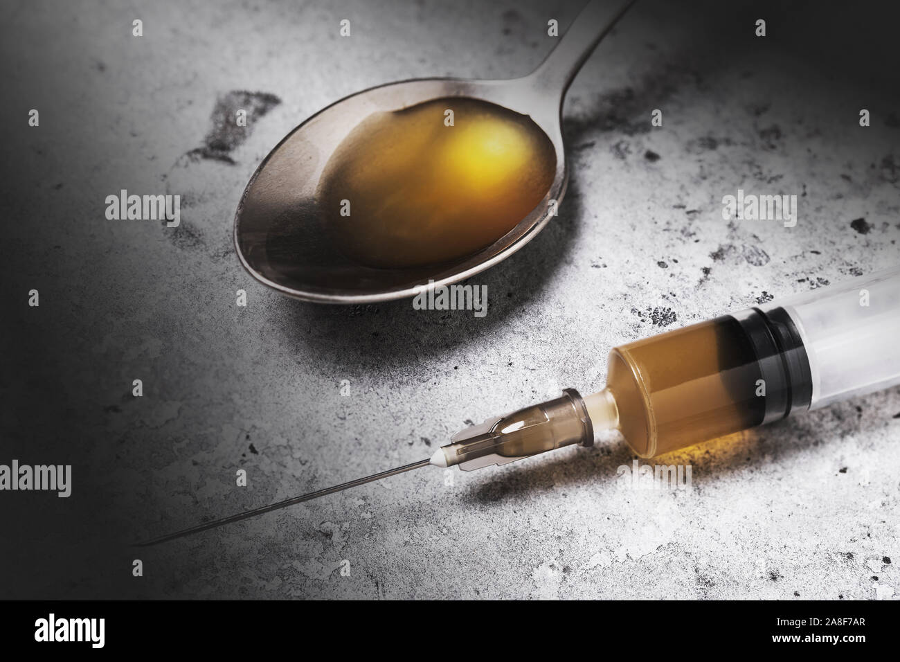 Narcotic is the enemy of the modern world. Drug in a syringe and spoon, closeup Stock Photo