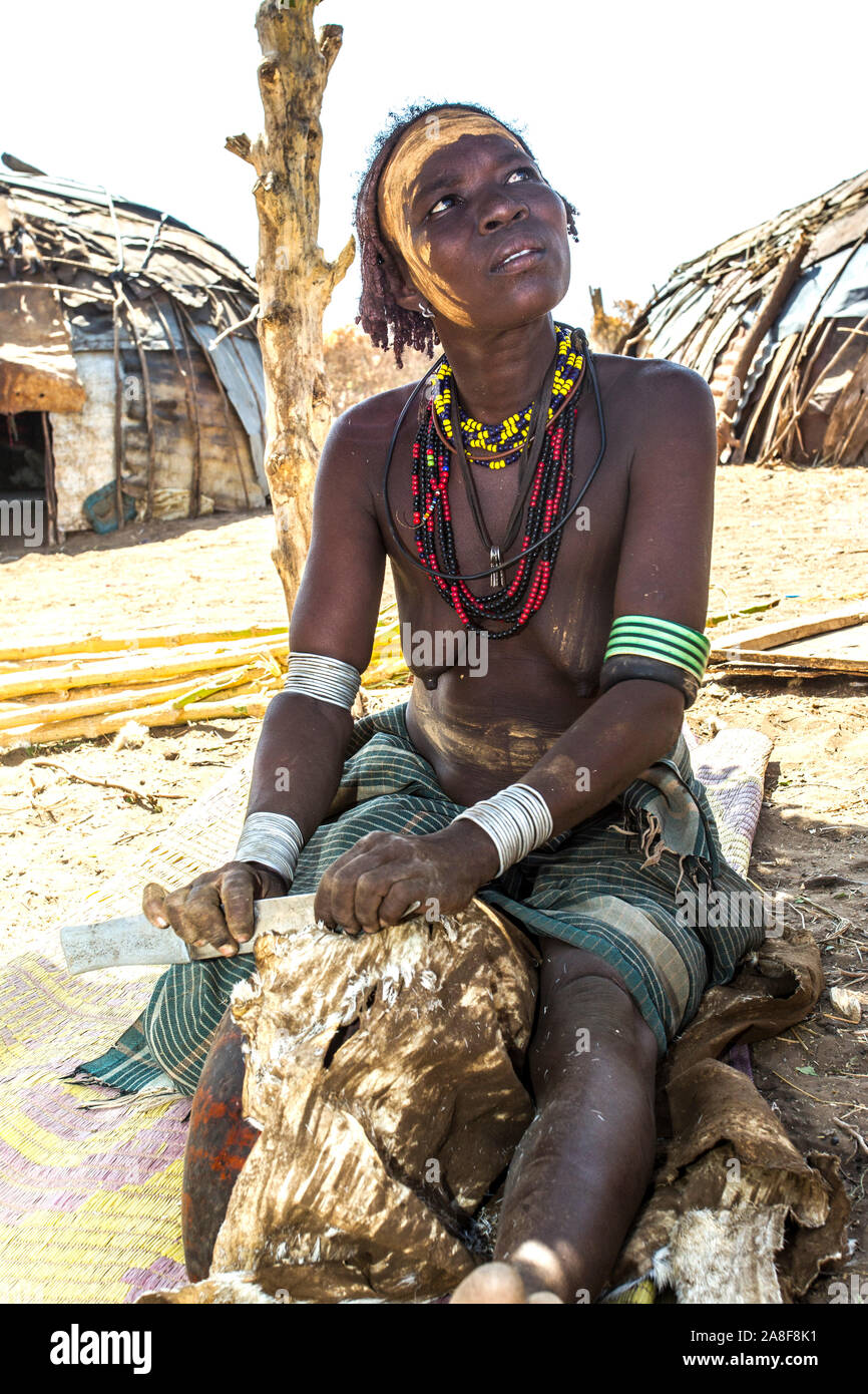 Dassenach tribe woman scraping a skin Ethiopia Stock Photo