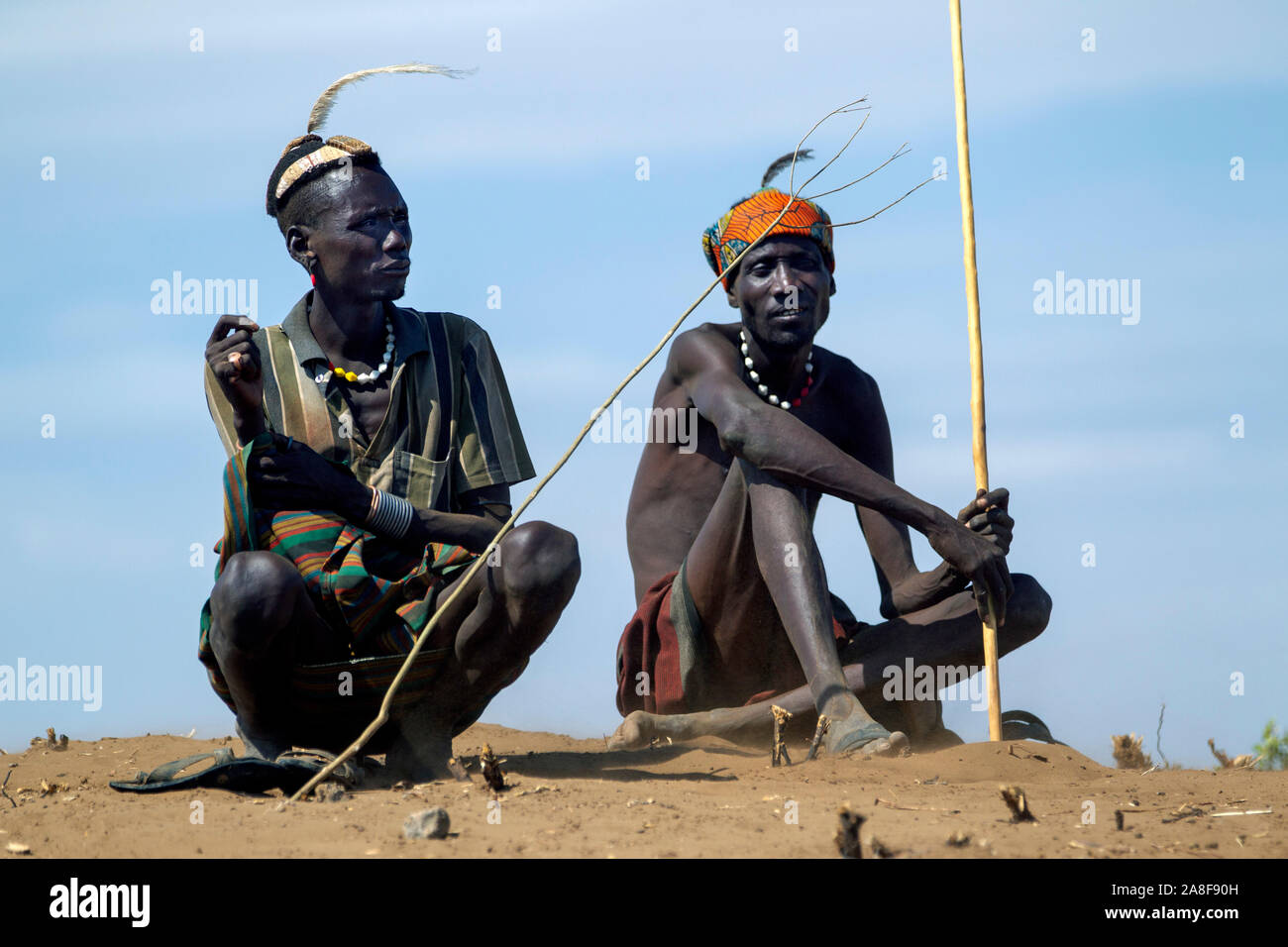 Dassenach tribe men watch over cattle near Omorate Ethiopia Stock Photo