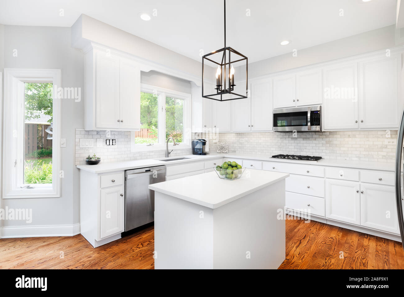 A Bright Kitchen With White Cabinets White Granite Counter Tops
