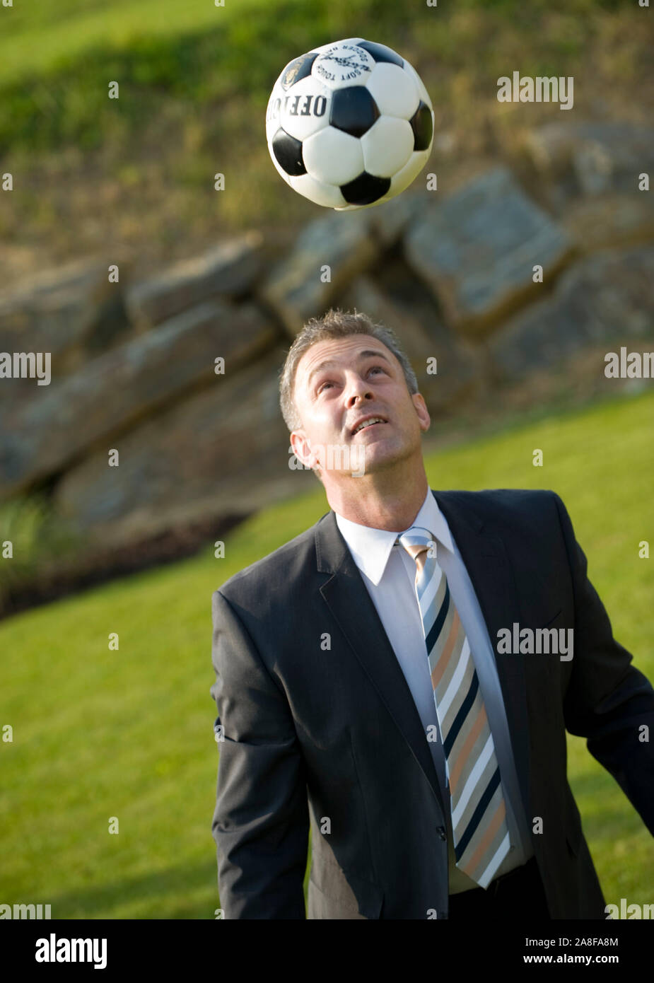 Gecshäftsmann spielt Fussball, Pause, Mittagspause, MR:Yes Stock Photo