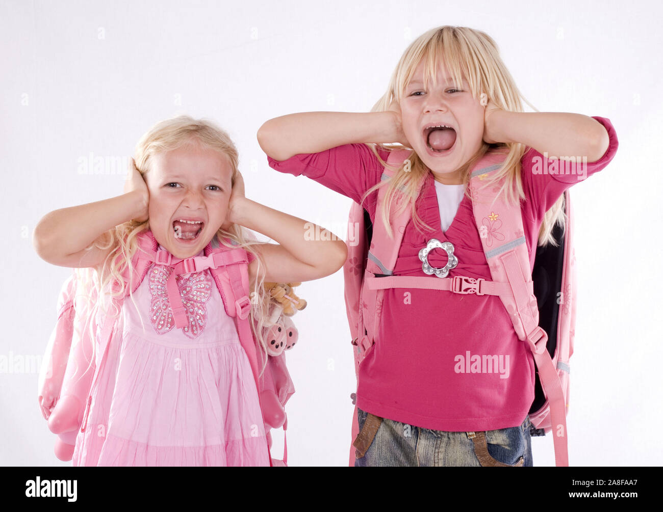 Zwei Mädchen, blond, 6, 7, Jahre, halten sich die Ohren zu, Schreien, MR:Yes Stock Photo