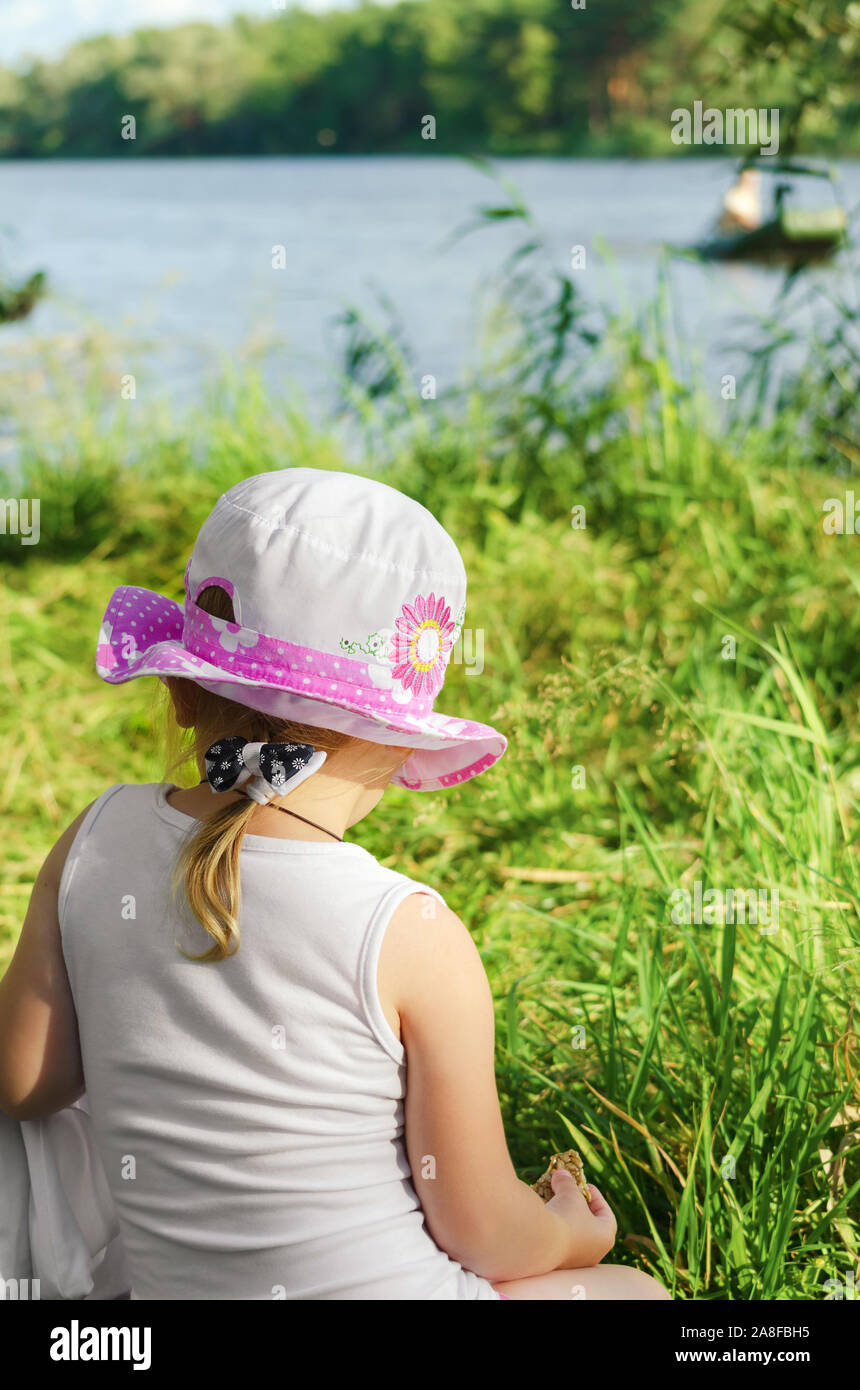 A little girl rests by the river Stock Photo - Alamy