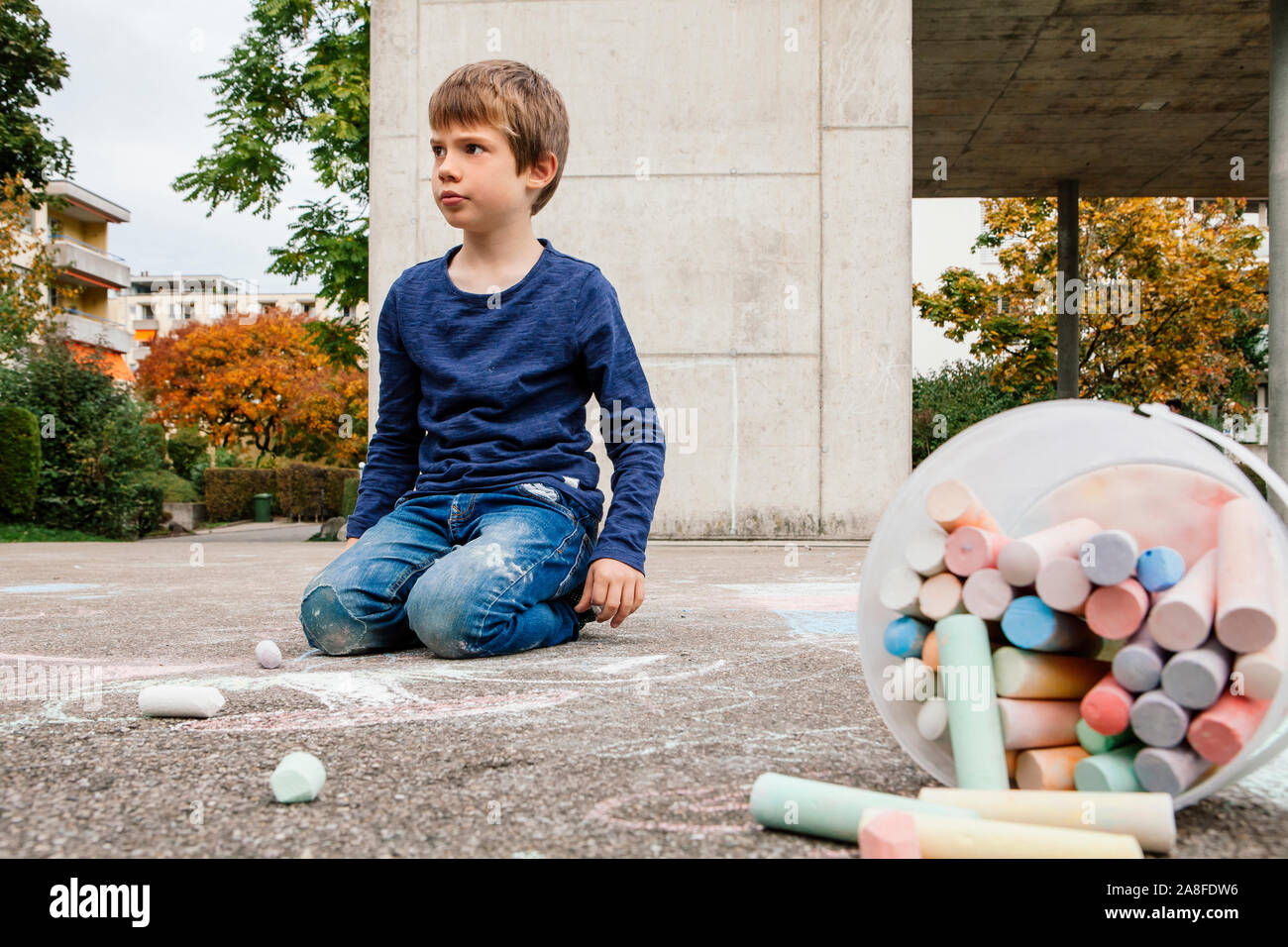 Young boy drawing outside on the sidewalk with chalk Stock Photo - Alamy