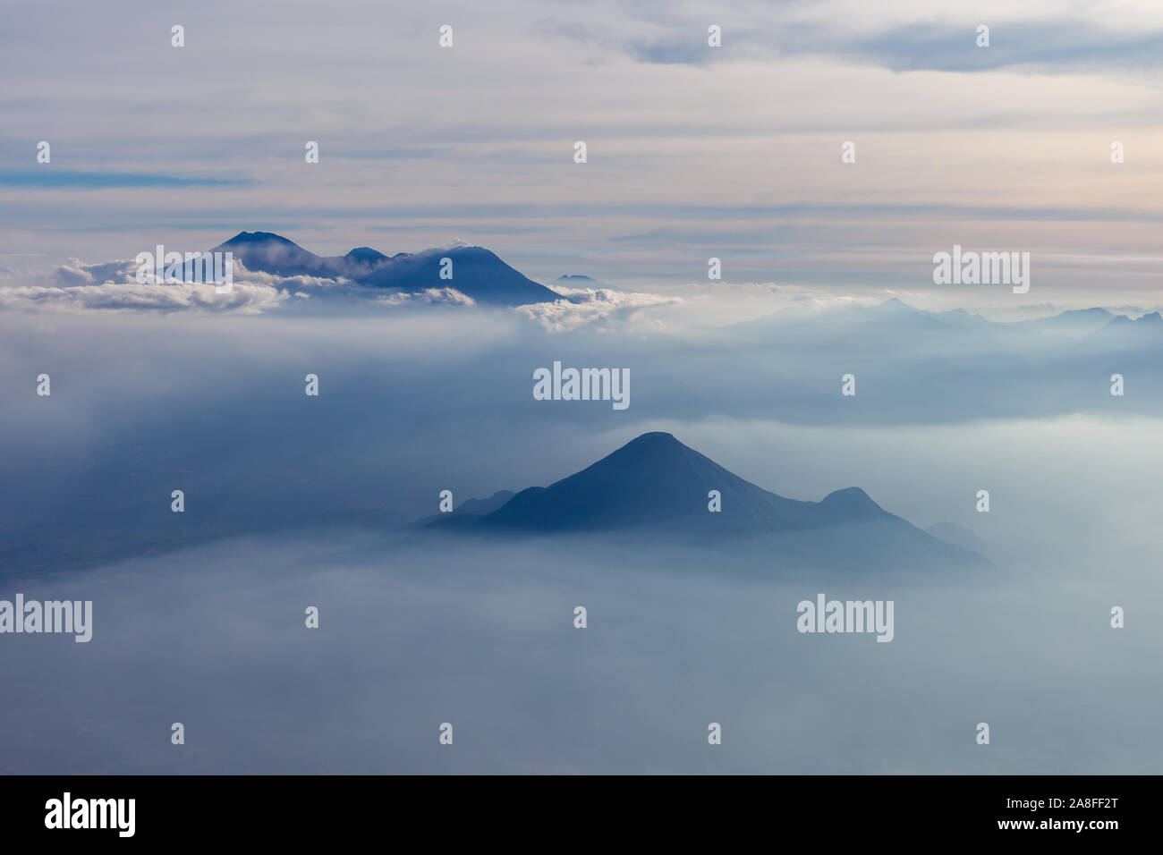 Aerial view of different volcanoes on Java Island. The fog adds to a mystical appearance of these sleeping beauties. Stock Photo