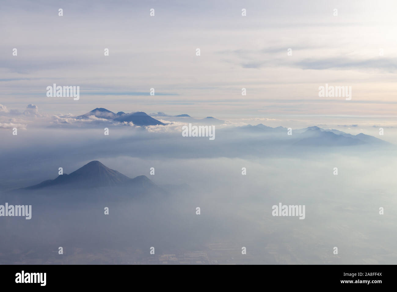 Aerial view of different volcanoes on Java Island. The fog adds to a mystical appearance of these sleeping beauties. Stock Photo